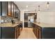 Modern kitchen featuring dark cabinets, stainless steel appliances, granite countertops, and a tile backsplash at 185 Hamlet Loop, Davenport, FL 33837