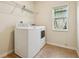 Laundry room with washer, dryer, and overhead shelving next to a window at 185 Hamlet Loop, Davenport, FL 33837