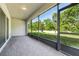Covered patio with brick flooring and screen enclosure overlooks the backyard at 185 Hamlet Loop, Davenport, FL 33837