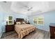 Main bedroom with tray ceiling, wood floors, plantation shutters, and coordinated furniture at 1910 Quiet Oak Ct, The Villages, FL 32162