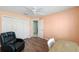 This bedroom features wood floors, a ceiling fan, and a large closet at 1910 Quiet Oak Ct, The Villages, FL 32162