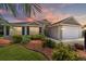 Charming single-story home featuring manicured landscaping, a two-car garage, and a welcoming entrance at 1910 Quiet Oak Ct, The Villages, FL 32162