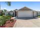 Attractive home with a spacious driveway, well-maintained lawn, and beautiful landscaping at 1910 Quiet Oak Ct, The Villages, FL 32162