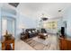 Bright and airy living room with wood-look flooring, ceiling fan, and comfortable seating at 1910 Quiet Oak Ct, The Villages, FL 32162