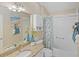 Bathroom featuring a shower-tub combo with granite vanity and beach-themed decor at 1963 Ladyfish Ave, The Villages, FL 32162
