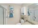 Well-lit bathroom with shower, decorative art, and storage cabinet at 1963 Ladyfish Ave, The Villages, FL 32162