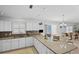 Bright kitchen features white cabinets, granite counters, and a breakfast bar overlooking the dining area at 1963 Ladyfish Ave, The Villages, FL 32162