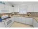 Bright kitchen featuring white cabinetry, a granite countertop, and modern appliances at 1963 Ladyfish Ave, The Villages, FL 32162