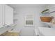 Laundry room with sink, cabinets, and shelving providing ample storage at 1963 Ladyfish Ave, The Villages, FL 32162