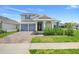 Charming home featuring a well-manicured lawn, an attached two-car garage, and a welcoming front porch with decorative pillars at 2025 Axel St, Minneola, FL 34715