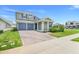 Charming home featuring a well-manicured lawn, an attached two-car garage, and decorative pillars on the front porch at 2025 Axel St, Minneola, FL 34715