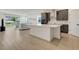 Open-concept kitchen and living room with wood floors and an island at 2025 Axel St, Minneola, FL 34715