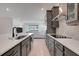 Modern kitchen features gray cabinets, stainless steel appliances, and a view into the living room at 2025 Axel St, Minneola, FL 34715