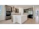 Modern kitchen featuring stainless appliances, quartz countertops, and stylish gray cabinets at 2025 Axel St, Minneola, FL 34715