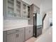 Stylish kitchen with gray cabinets, a modern fridge, sleek countertops, and a decorative backsplash at 2025 Axel St, Minneola, FL 34715