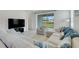 Open-concept living room featuring stylish furniture, a large TV, and access to the outdoors at 2025 Axel St, Minneola, FL 34715