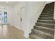 Carpeted staircase with white walls leads to the upper level of this bright home at 2025 Axel St, Minneola, FL 34715