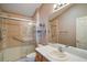 Well-lit bathroom features tile shower, hand rails, a single sink vanity, and ample mirror space at 2050 Duval Ct, The Villages, FL 32162