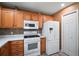 Bright kitchen with wood cabinets, white appliances, and a tile backsplash at 2050 Duval Ct, The Villages, FL 32162
