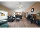 Spacious living room with wood floors, a ceiling fan, and an open view into the kitchen at 2050 Duval Ct, The Villages, FL 32162