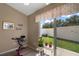 An exercise bike sits in front of a sliding glass door that leads to a covered patio and garden at 2050 Duval Ct, The Villages, FL 32162