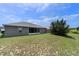 Backyard with a well-maintained lawn and gray exterior of the house at 211 Highland Meadows Ct, Davenport, FL 33837