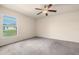 Bedroom featuring neutral carpet, ceiling fan, and window with backyard view at 211 Highland Meadows Ct, Davenport, FL 33837