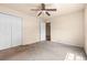 Bedroom with carpet, ceiling fan, closet and view to another room through an open door at 211 Highland Meadows Ct, Davenport, FL 33837