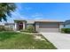 Charming single-story home with a well-maintained lawn and inviting front entrance with mature landscaping at 211 Highland Meadows Ct, Davenport, FL 33837