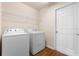 Bright laundry room with washer, dryer, wire shelving, and wood-look flooring at 211 Highland Meadows Ct, Davenport, FL 33837