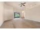 Spacious living room featuring neutral walls, plush carpeting, ceiling fan, and sliding door to the exterior at 211 Highland Meadows Ct, Davenport, FL 33837