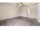 Neutral main bedroom featuring carpet, ceiling fan, a walk-in closet, and an ensuite bathroom at 211 Highland Meadows Ct, Davenport, FL 33837
