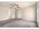 Spacious main bedroom with neutral walls, plush carpeting, ceiling fan, and easy access to ensuite bathroom at 211 Highland Meadows Ct, Davenport, FL 33837
