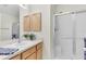 Bathroom with a glass-door shower, vanity with storage, and ample lighting at 2111 Thornton Ter, The Villages, FL 32162