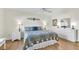 Spacious bedroom with a decorative comforter set, ceiling fan, and hardwood floors at 2111 Thornton Ter, The Villages, FL 32162