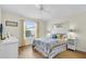 Bedroom with neutral walls, wood floors, and large windows overlooking the neighborhood at 2111 Thornton Ter, The Villages, FL 32162