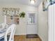 Bright dining area with white table and chairs, wood floors, and a door to the screened patio at 2111 Thornton Ter, The Villages, FL 32162