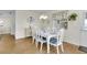 Dining room with seating for six, wood floors, and decorative plates on the wall at 2111 Thornton Ter, The Villages, FL 32162