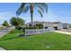 Exterior with lush green lawn and well-maintained shrubs in front of home at 2111 Thornton Ter, The Villages, FL 32162
