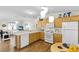 Open kitchen with light wood cabinets, modern appliances, and breakfast table at 2111 Thornton Ter, The Villages, FL 32162