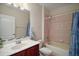 Bathroom featuring a vanity, toilet, and a shower/tub combination with tiled walls and shower curtain at 21206 Canoe Pass St, Clermont, FL 34715