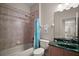 Bathroom featuring a tub shower combo, pink tile, and a green marble vanity at 21206 Canoe Pass St, Clermont, FL 34715
