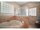 A bathtub and shower are surrounded by tile and windows at 21206 Canoe Pass St, Clermont, FL 34715
