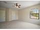 Light-filled bedroom featuring neutral walls, carpet flooring, ceiling fan and a window with natural light at 21206 Canoe Pass St, Clermont, FL 34715