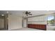 Spacious bonus room featuring neutral walls, carpet flooring, ceiling fan, and built in cabinetry at 21206 Canoe Pass St, Clermont, FL 34715