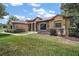Charming single-story home features a stone facade, manicured lawn, and inviting walkway leading to the front entrance at 21206 Canoe Pass St, Clermont, FL 34715