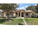 Charming home with stone accents, manicured landscaping, and a welcoming entrance at 21206 Canoe Pass St, Clermont, FL 34715