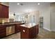 Kitchen showcasing a center island, stainless steel dishwasher, and easy access to the living room at 21206 Canoe Pass St, Clermont, FL 34715
