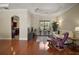 Cozy living room boasts hardwood floors, tray ceiling, elegant molding, and natural light through the window at 21206 Canoe Pass St, Clermont, FL 34715