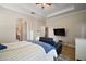 Spacious main bedroom with a ceiling fan, television, and arched entry to the main bath at 21206 Canoe Pass St, Clermont, FL 34715